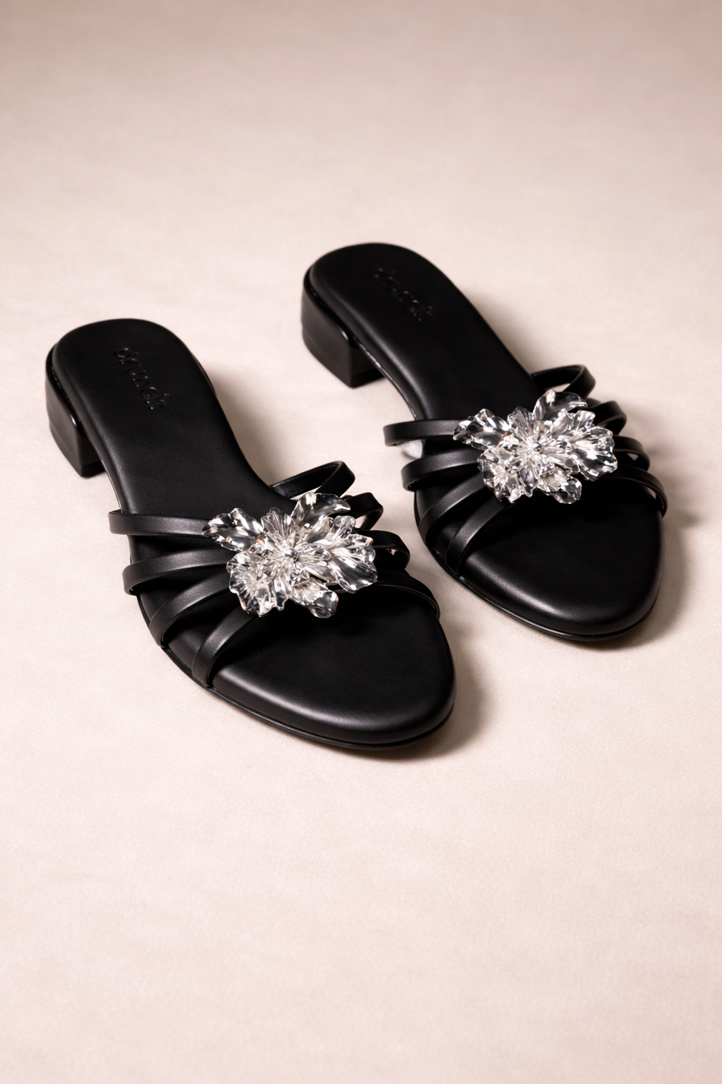 Everglow Flat Sandals in Black – Detail View of Silver Floral Buckle Embellishment | Drunch